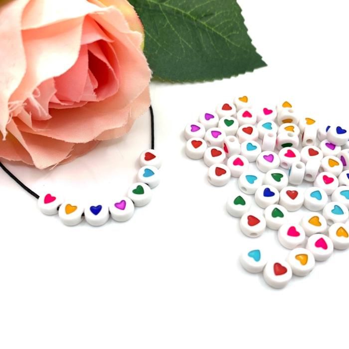 Perles rondes colorées avec motifs d’amour en acrylique pour création de bijoux.